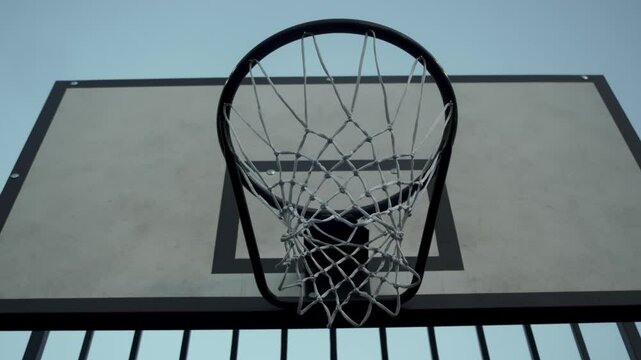 The ball finally makes its way into the basketball hoop after bouncing and ricocheting several times. Close up.