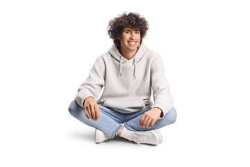 Young man with curly hair sitting with crossed legs