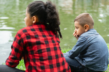 Children looking at the lake while chatting in the park