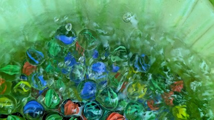 Clear marbles in water - abstract colorful background with glass marbles  