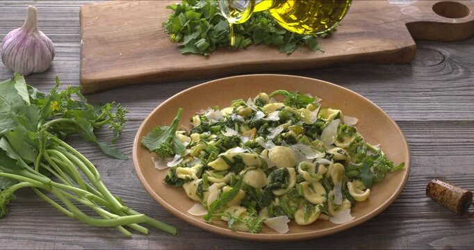 Pouring olive oil over orecchiette pasta with homegrown broccoli rabe (rapini). Rapini is a rich source of vitamin K. 