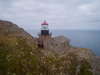Point Sur Lighthouse stands on a cliff, guiding ships along the rugged California coast in Big Sur,...