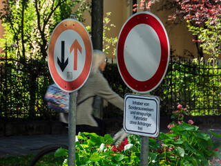 Bicyclist Navigating Urban Landscape with Traffic Signs