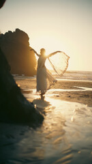 A girl in a sari dances against the backdrop of the ocean at sunset. Meditation.  Yoga. Soft focus