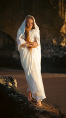 A girl in a sari dances against the backdrop of the ocean at sunset. Meditation.  Yoga. Soft focus