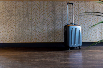 Hotel and hospitality concept, Selective focus of a suitcase in front of reception desk, Small hand...