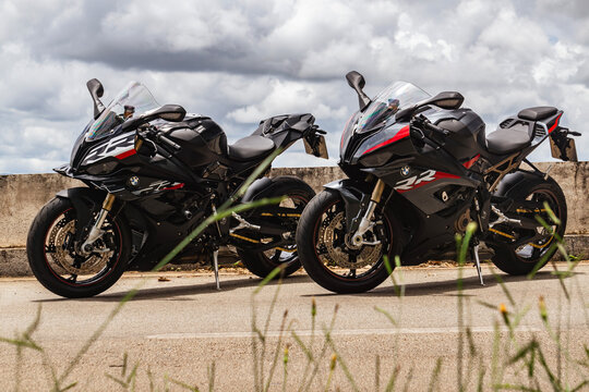 A pair of black BMW S1000RR superbikes parked on a road


