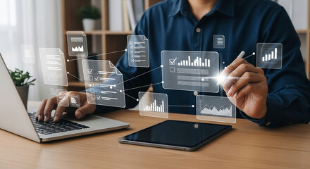 Man using laptop and tablet with floating data graphics for business analytics and management tasks