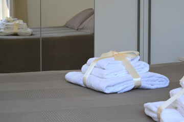 asciugamani bianchi puliti sul letto di un appartamento di un hotel © Andrea_Veneziano