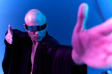 A man in futuristic attire with sunglasses strikes a dynamic pose, exuding confidence and mystery....
