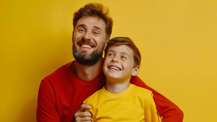 Obraz premium Father hugging happy child in bright yellow background