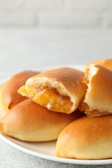 Tasty baked patties with orange jam on light grey table, closeup