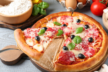 Tasty pizza and ingredients on grey wooden table, closeup