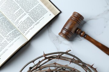 Judge's gavel, Bible and crown of thorns on white marble table, flat lay