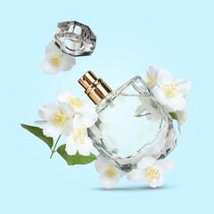 Bottle of floral perfume and jasmine flowers in air on light blue background