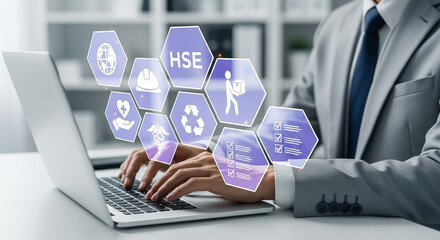 Man typing on laptop with hse icons floating above keyboard in office setting with shelves behind him