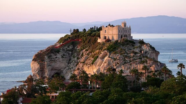 Sanctuary of Santa Maria dell Isola on a steep cliff overlooking Tropea at sunset, Calabria, Italy