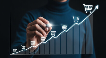 Man drawing an upward trending graph with shopping cart icons on a dark background in a studio shot