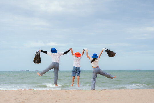 Group of friends cleaning the beach while enjoying their time together under a cloudy sky