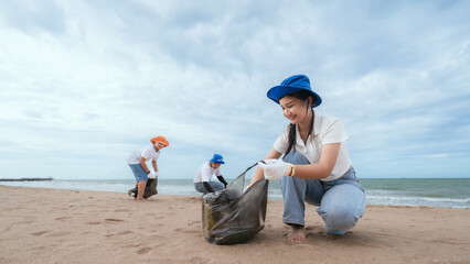 Volunteers clean the beach while collecting plastic waste on a cloudy day near the shoreline