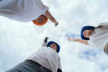 Team members wearing hats and gloves join hands in support during an outdoor community activity in...