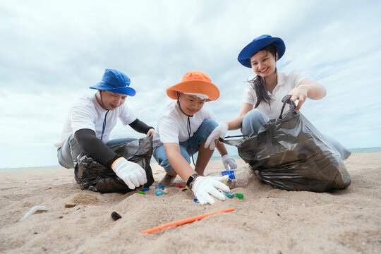 Community members clean up beach during environmental initiative on a cloudy dayCommunity members clean up beach during environmental initiative on a cloudy day