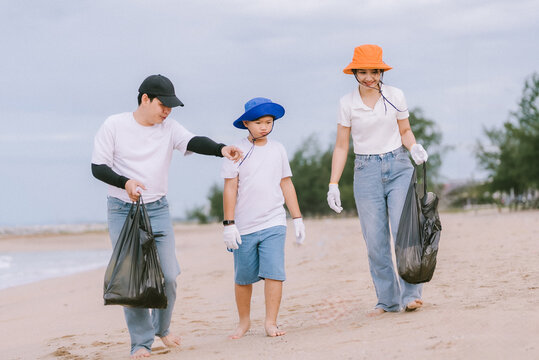 Family participates in beach cleanup activity while promoting environmental awareness on a cloudy day