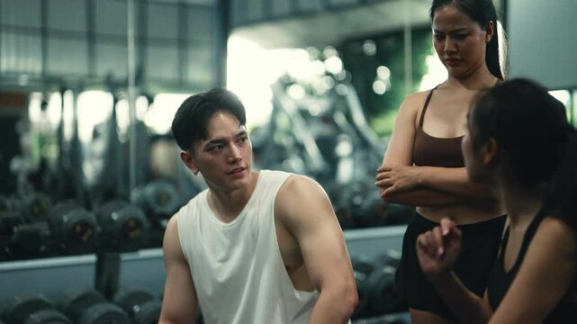 Fitness professionals providing guidance and support to client, emphasizing importance of proper form and technique