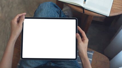 Naklejka premium Mockup image of woman using digital tablet with blank white screen during working at coffee shop, close up. Mockup tablet for online marketing or web template