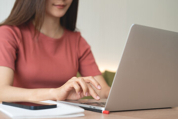Young asian business woman working remotely, using laptop computer, surfing the internet at coffee...