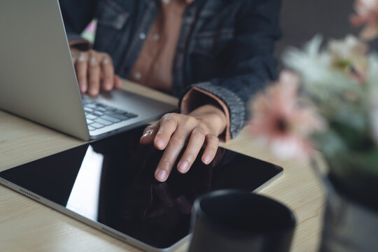 Woman using digital tablet, working on laptop computer at office. Remote working, using tablet pc and laptop, surfing the internet, searching the information