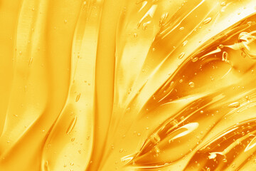 Gel texture background. Vitamin C serum, yellow skincare gel cream close up