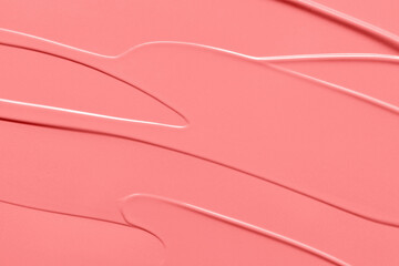 Blush cream, lipstick background. Coral color creamy makeup product or paint texture