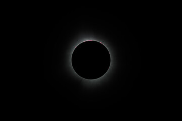 Solar eclipse during totality with corona and solar flares visible
