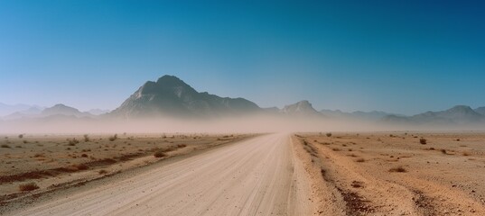 Vast panoramic desert landscape with distant mountains and a straight road leading to the horizon, featuring dust clouds, dry terrain, and atmospheric particles under a muted, cinematic tone