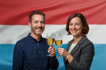 Happy couple toasting with white wine against a Luxembourg flag. Man and woman celebrating with a drink. Luxembourgish National Day