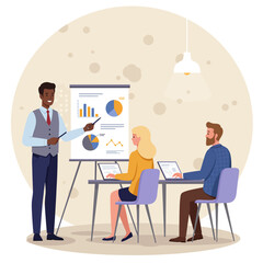 Man presenting graphs to colleagues sitting with laptops at a table in a room with a lamp