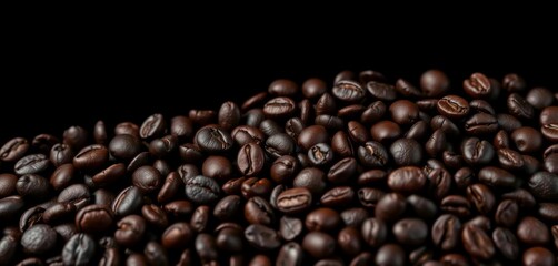 Obraz premium Intense close-up of dark roasted coffee beans against a black backdrop, photography, drink