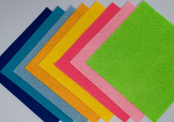 Colorful felt fabric sheets arranged diagonally in rainbow hues