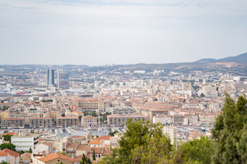 The urban landscape stretches far and wide, with distant mountains and numerous buildings under a...