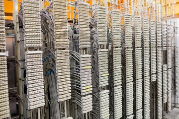Flat design illustration is showing telecommunication racks with terminal blocks and grey cables