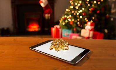 Digital table on wooden table against Christmas tree