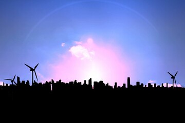 Image of silhouetted cityscape and wind turbines on pink sunset and clouds in blue sky, copy space