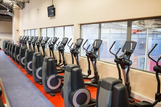 Fototapeta Cross trainers arranged in gym