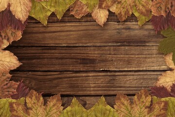Naklejka premium Border of dried autumn leaves is framing horizontal rustic wooden planks in flat design