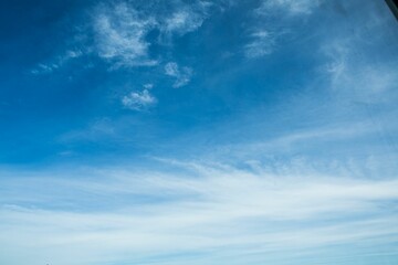 Obraz premium Deep blue sky is stretching across frame with wispy cirrus clouds in flat design