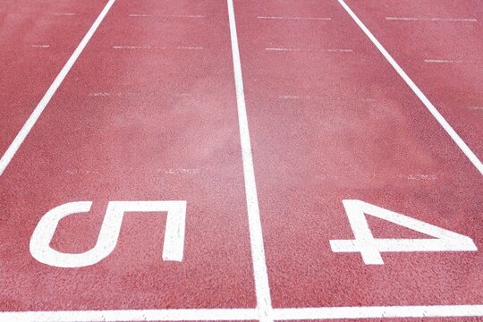 Fototapeta Red synthetic track lanes are showing in flat style with white lines and numbers 5,4