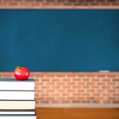 Red apple on pile of books in classroom