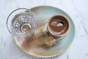 Traditional turkish coffee with water served on a rustic plate