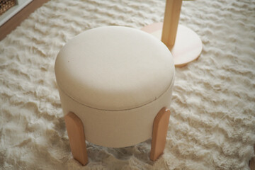 Soft round ottoman on fluffy rug in a cozy room